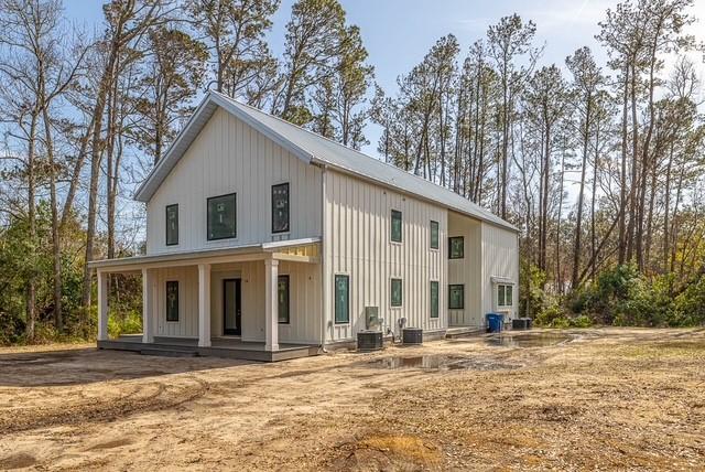 back of house with central air condition unit and a porch