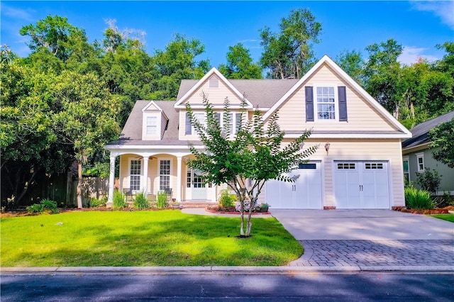 view of front of property with covered porch, a front yard, and a garage