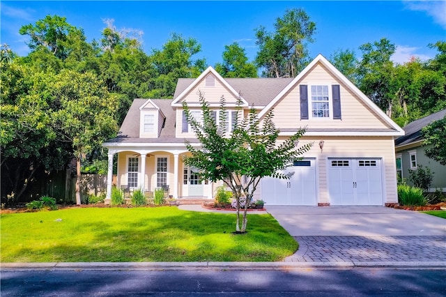 163 N Cottages Dr, Saint Simons Island, GA 31522 - traditional-style house with concrete driveway, a front lawn, a porch, and a garage