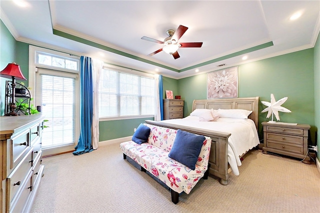 carpeted bedroom featuring a raised ceiling, ceiling fan, and crown molding