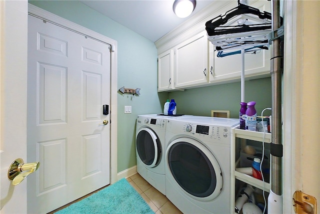 laundry room featuring washing machine and dryer, light tile patterned floors, and cabinets