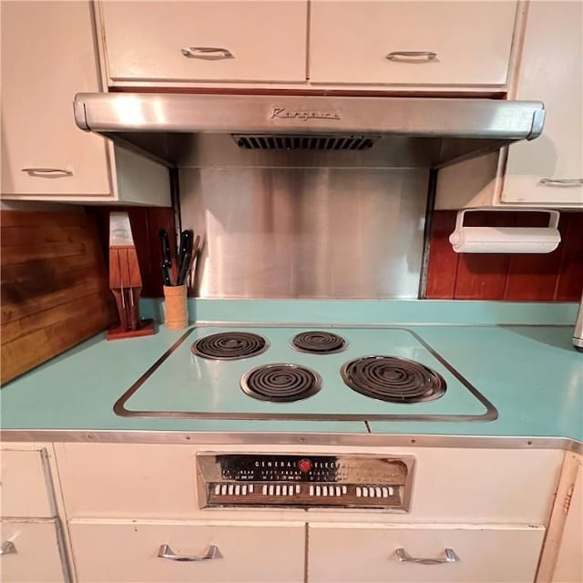 kitchen with white cabinetry, range, and under cabinet range hood