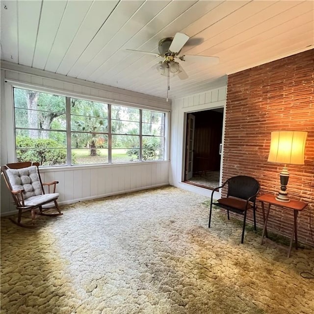 sunroom featuring a ceiling fan and wood ceiling