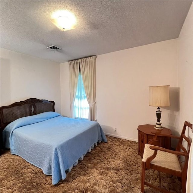 bedroom featuring carpet, visible vents, a textured ceiling, and baseboards