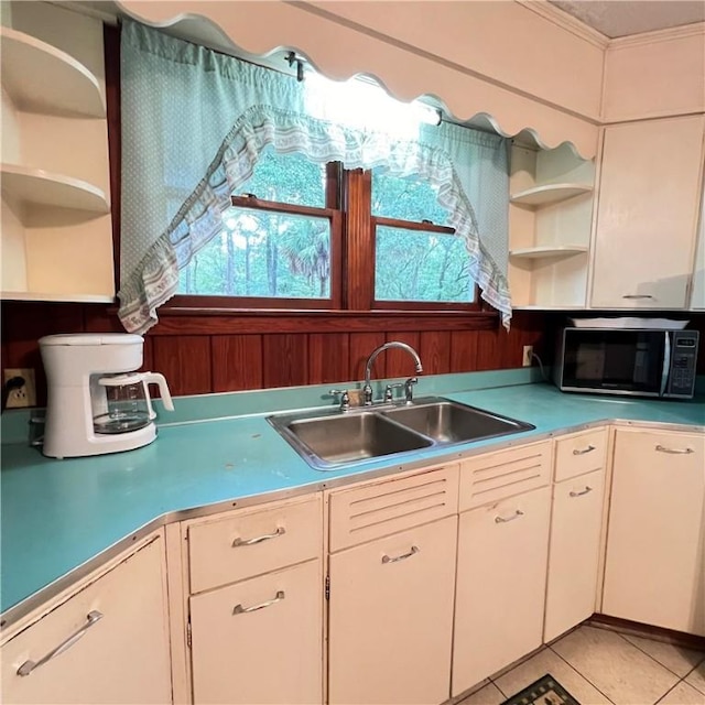 kitchen featuring light tile patterned floors, open shelves, a sink, and light countertops