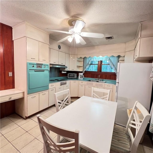 kitchen with visible vents, wall oven, freestanding refrigerator, a ceiling fan, and under cabinet range hood