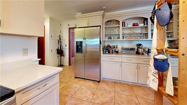 kitchen with stainless steel fridge, light tile patterned floors, and crown molding