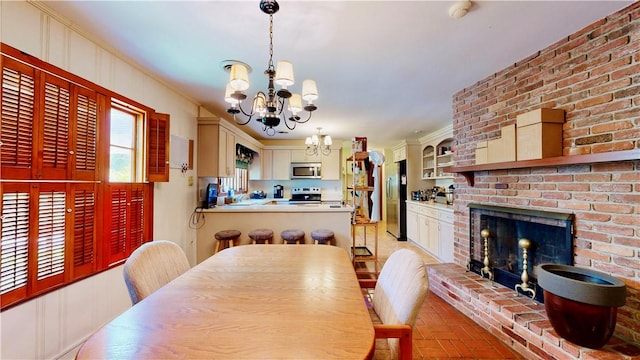 dining room featuring a notable chandelier, ornamental molding, and a fireplace