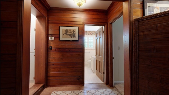 corridor featuring wooden walls and light hardwood / wood-style floors