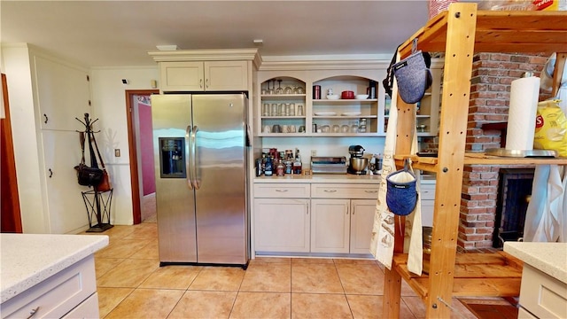 kitchen featuring stainless steel fridge, crown molding, and light tile patterned floors