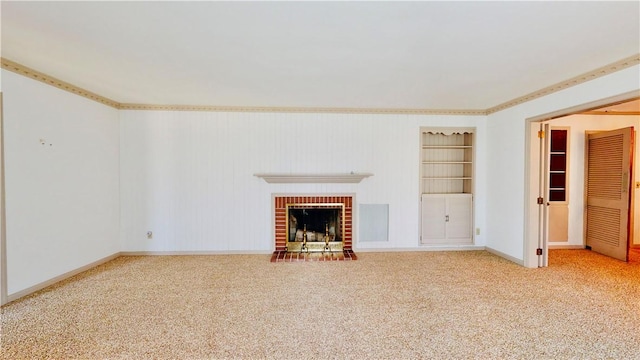 unfurnished living room with carpet flooring, built in shelves, and a brick fireplace