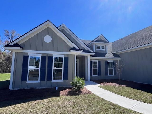 view of front of property with board and batten siding and a front lawn