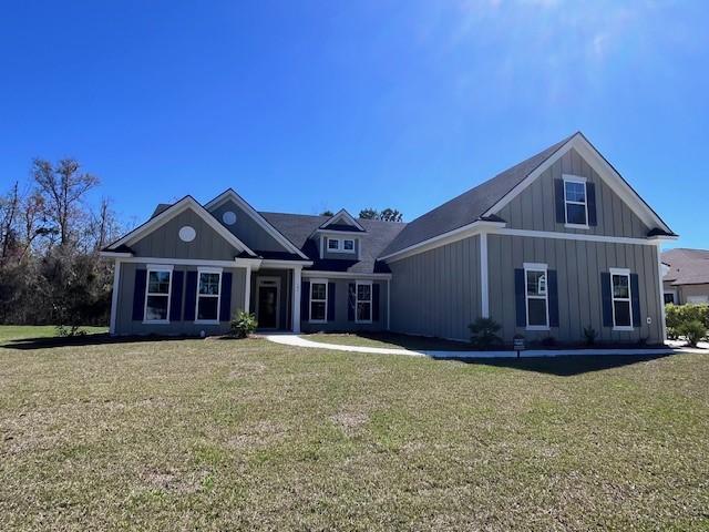 view of front facade with board and batten siding and a front yard