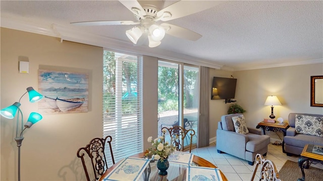 tiled dining room featuring crown molding, ceiling fan, and a textured ceiling