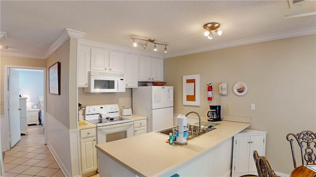 kitchen featuring sink, kitchen peninsula, a textured ceiling, white appliances, and white cabinets