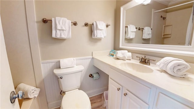 bathroom featuring vanity, a shower, crown molding, hardwood / wood-style flooring, and toilet