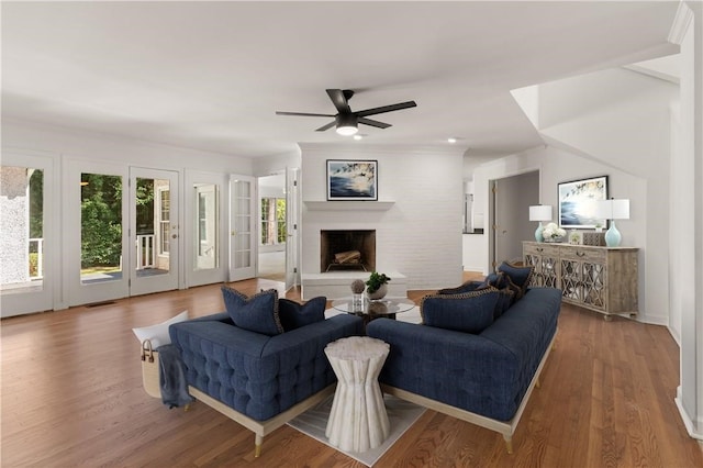 104 Augusta, Saint Simons Island, GA 31522 - living area featuring a fireplace with raised hearth, a ceiling fan, wood finished floors, and visible vents