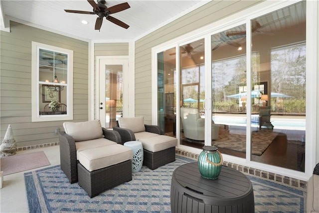 sunroom / solarium featuring ceiling fan