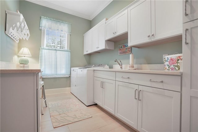 clothes washing area with cabinet space, ornamental molding, a sink, independent washer and dryer, and baseboards