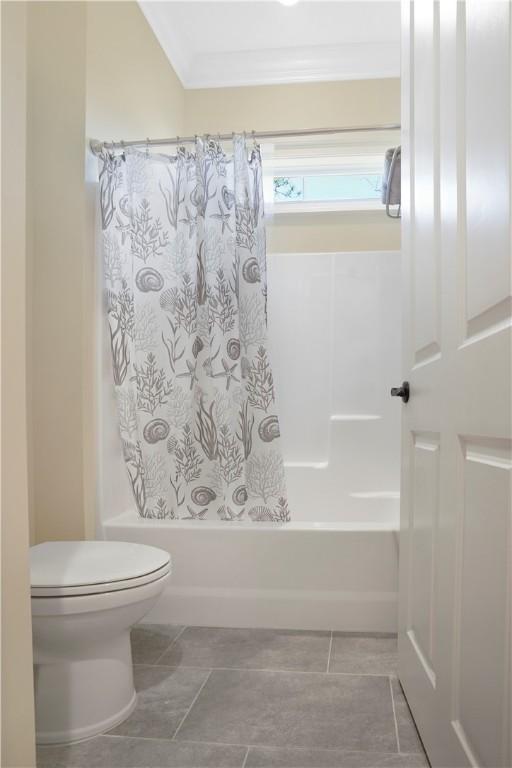 bathroom featuring crown molding, shower / tub combo with curtain, and toilet