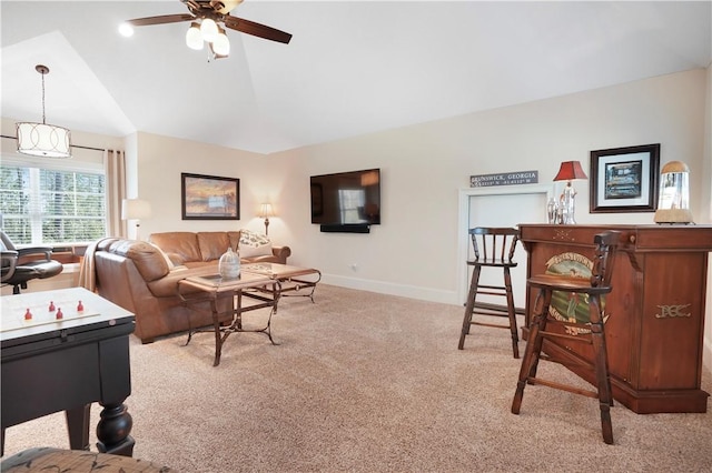 living room with lofted ceiling, baseboards, a ceiling fan, and light colored carpet