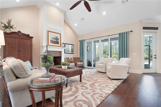 living area featuring a fireplace, high vaulted ceiling, dark wood-style flooring, and a wealth of natural light