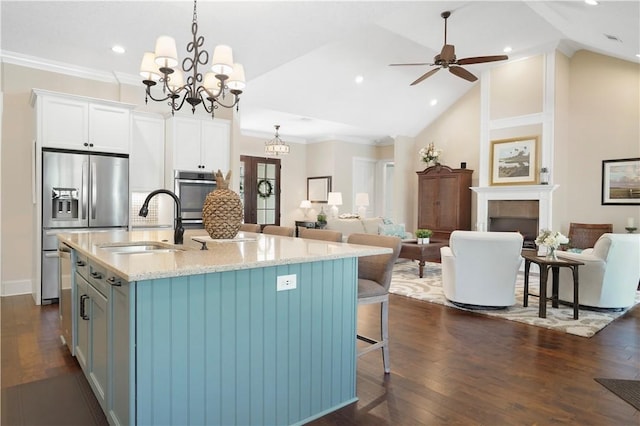 kitchen featuring open floor plan, dark wood-style flooring, a sink, and light stone countertops