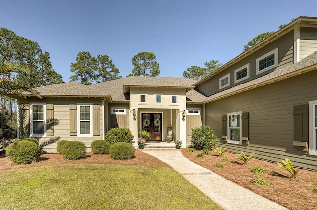 view of front of home featuring french doors, a front lawn, and roof with shingles