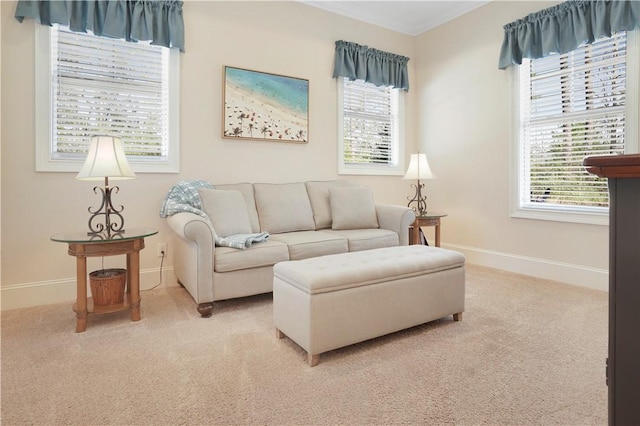 living area featuring a healthy amount of sunlight, baseboards, and light colored carpet