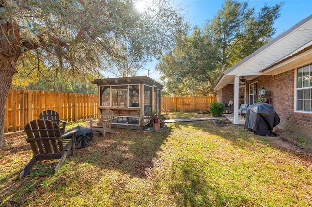 view of yard with a sunroom and a fenced backyard