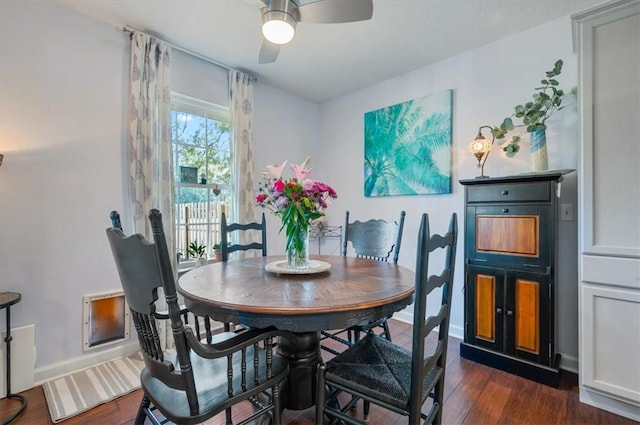 dining space with a ceiling fan, baseboards, and dark wood-style flooring