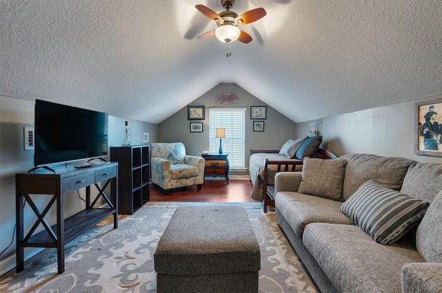 interior space with lofted ceiling, ceiling fan, a textured ceiling, and wood finished floors