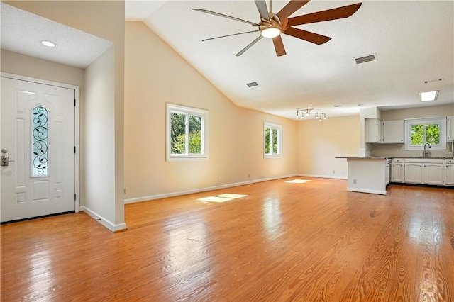 310 Peachtree St, Saint Simons Island, GA 31522 - unfurnished living room with ceiling fan, light wood finished floors, and lofted ceiling