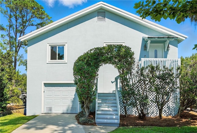 310 Peachtree St, Saint Simons Island, GA 31522 - view of front facade with stairway, a garage, stucco siding, and driveway