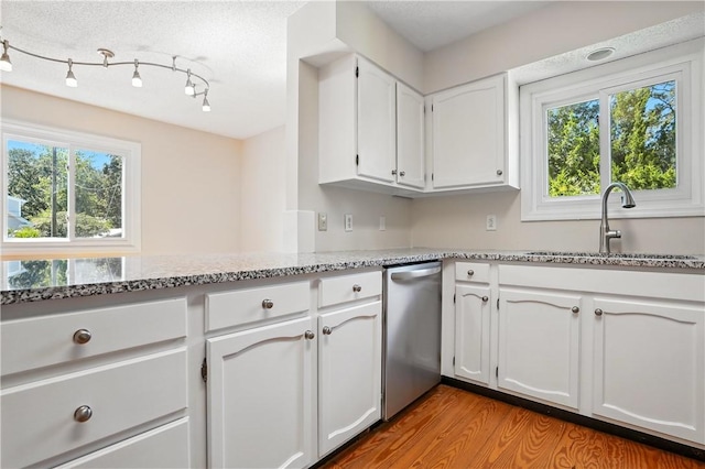 310 Peachtree St, Saint Simons Island, GA 31522 - kitchen featuring dishwasher, light stone counters, light wood-style flooring, and white cabinetry
