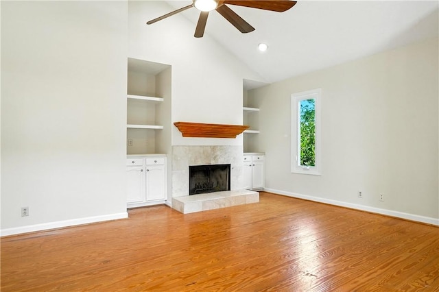 310 Peachtree St, Saint Simons Island, GA 31522 - unfurnished living room with a tiled fireplace, a ceiling fan, built in features, light wood-style flooring, and high vaulted ceiling