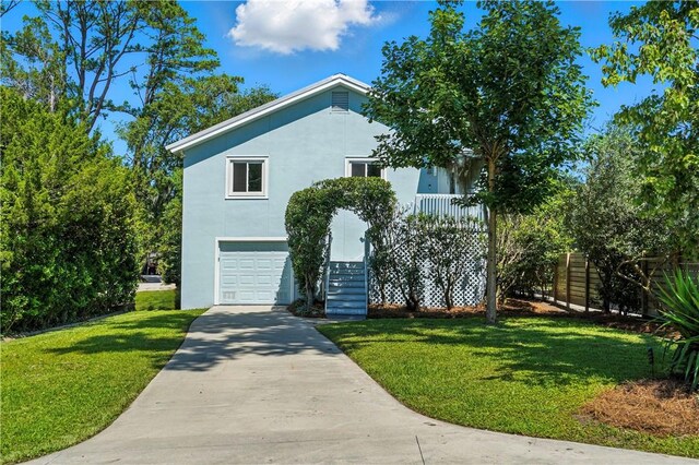 310 Peachtree St, Saint Simons Island, GA 31522 - view of front of home with stucco siding, stairway, a front lawn, concrete driveway, and a garage