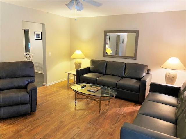 living room with wood finished floors, baseboards, and ceiling fan