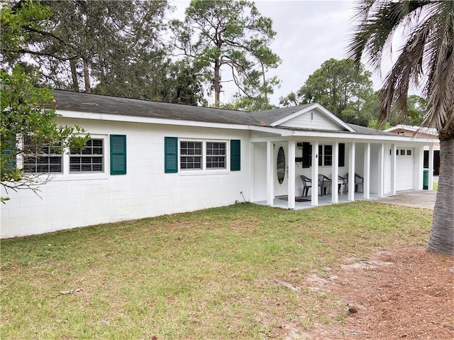 ranch-style house with a front lawn, an attached garage, concrete block siding, and a shingled roof