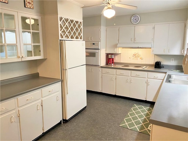 kitchen with a sink, under cabinet range hood, backsplash, white appliances, and ceiling fan