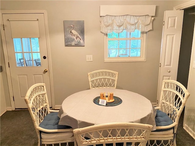 carpeted dining space featuring baseboards