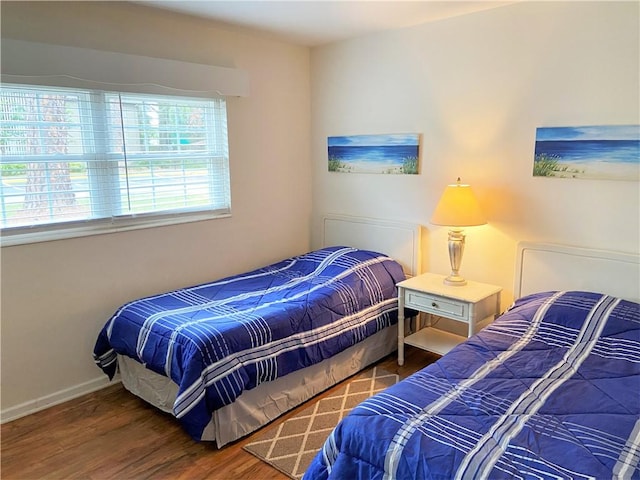 bedroom with baseboards and wood finished floors