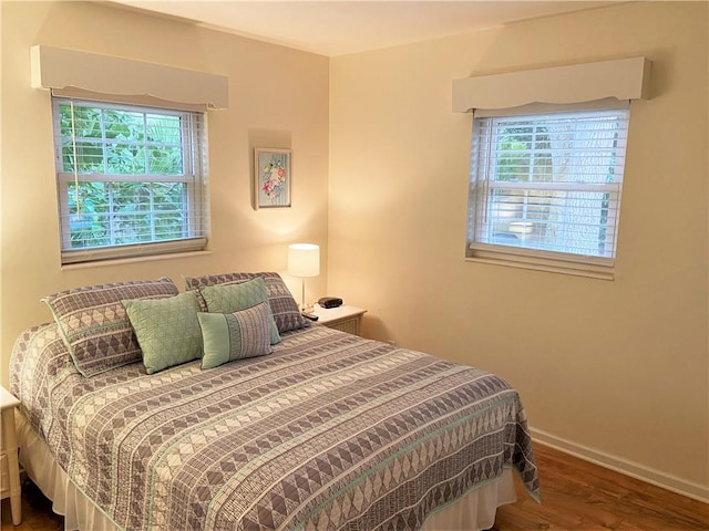 bedroom with baseboards and wood finished floors