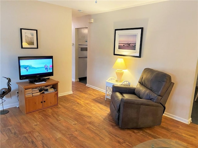 living area with baseboards and wood finished floors