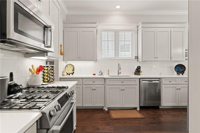 1073 Demere Rd, Saint Simons Island, GA 31522 - kitchen featuring stainless steel appliances, a sink, light countertops, crown molding, and backsplash