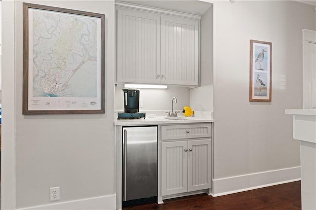 1073 Demere Rd, Saint Simons Island, GA 31522 - bar featuring stainless steel built in refrigerator, a sink, baseboards, and dark wood-type flooring
