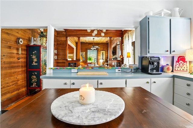604 Union St, Brunswick, GA 31520 - kitchen with wooden walls, light countertops, white cabinets, and ceiling fan