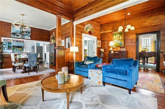 604 Union St, Brunswick, GA 31520 - living area with a chandelier, wood-type flooring, wood walls, beam ceiling, and decorative columns