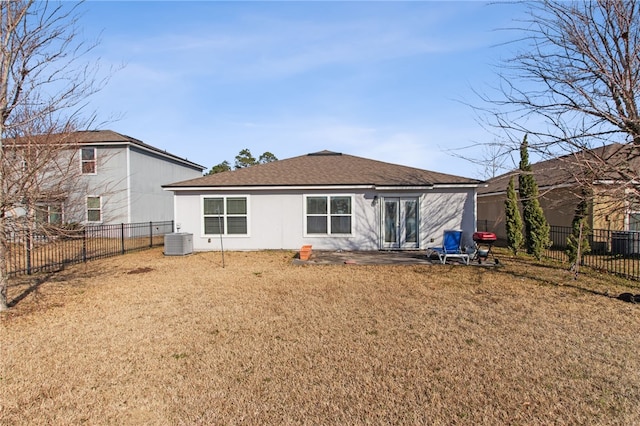 back of house with central AC unit and a lawn