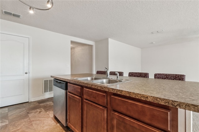 kitchen featuring dishwasher, sink, and a textured ceiling